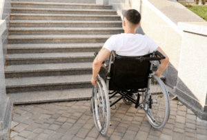 Wheelchair user facing steps creating an access barrier