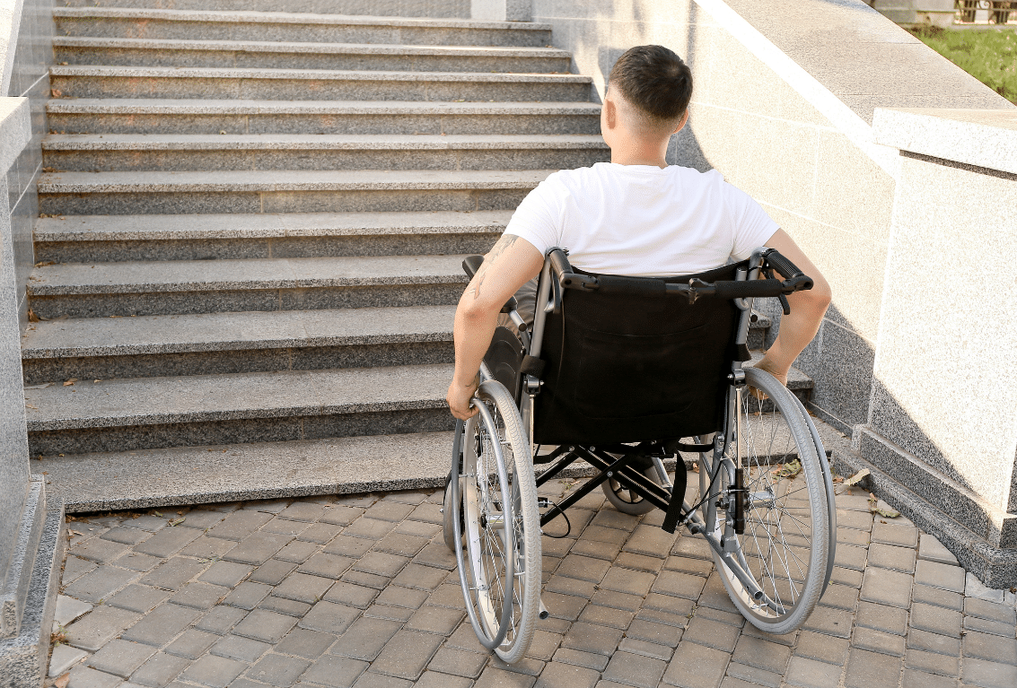 Wheelchair user facing steps creating an access barrier